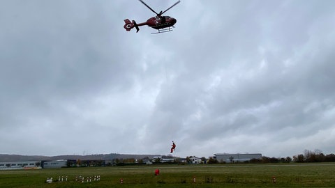 Hubschrauber mit Menschen am Seil