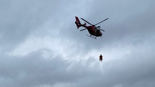 Hubschrauber mit Seilwinde und menschen