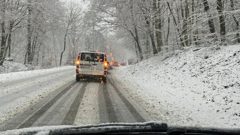 Die Straßen in der Nähe von Montabaur sind verschneit, Autos können nur langsam fahren.