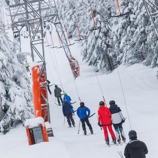 Skifahrer in einem Schlepplift - im Westerwald haben die ersten Skilifte geöffnet.