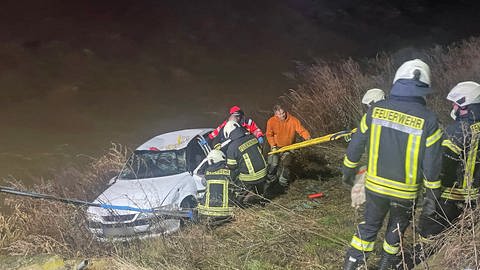 Feuerwehrleute holten in Altenahr den schwerverletzten Fahrer nach dem Sturz in die Ahr aus seinem Wagen.