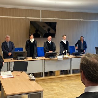 Richter und Besitzer stehen vor der Urteilsverkündung gegen fünf mutßmaßliche Mitglieder der Hells Angels im Koblenzer Gerichtssaal.