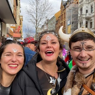 Drei fröhliche Karnevalisten beim Rosenmontagsumzug 2024 in Koblenz