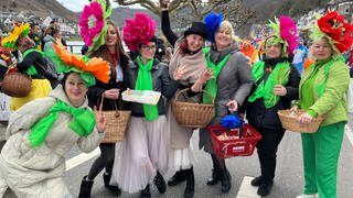 Frauen mit großen Blüten-Hüten beim Rosenmontagsumzug 2024 in Cochem.