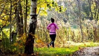 Eine Frau joggt durch einen Wald