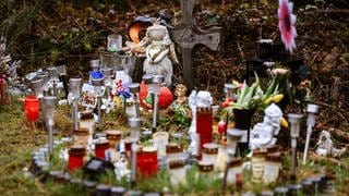 Kerzen, Blumen und Figuren liegen am Fundort der Leiche von Luise an der Landesgrenze zwischen Rheinland-Pfalz und Nordrhein-Westfalen.