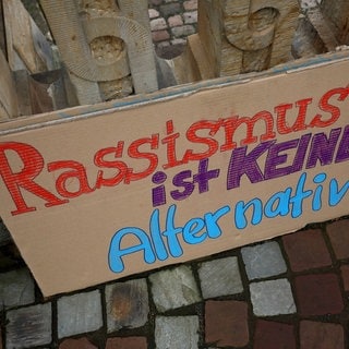 Pappschild mit der Aufschrift "Rassismus ist keine Alternative"