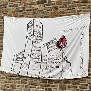 Banner an der St Andreas Kirche in Ahrbrück verdeutlicht Kritik an Abriss