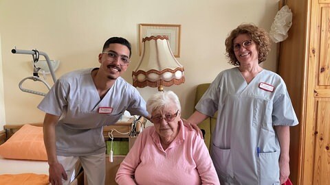 Soufiane Chahmat gemeinsam mit Bewohnerin Elisabeth Haferkorn und Wohnbereichsleiterin Silvia Schmitt.