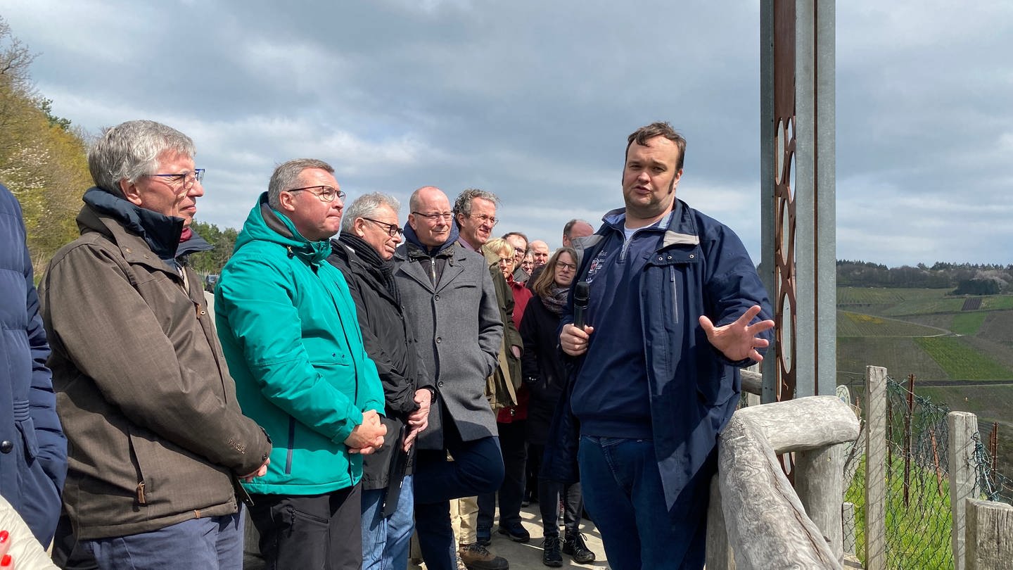 Menschen von der Enquete-Kommission des Landtags stehen in Dernau vor einem Weinberg