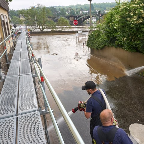 Feuerwehrleute reinigen in Koblenz die Straßen vom Schlamm, den das Hochwasser zurückgelassen hat.