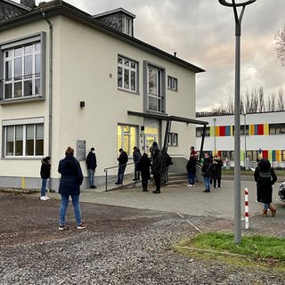 Menschen warten vor der Ärztlichen Bereitschaftspraxis am Kemperhof in Koblenz