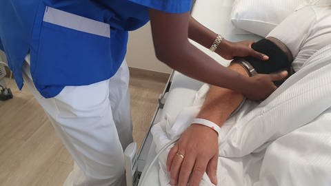 Pflegerin aus Namibia legt Blutdruckmessgerät bei Patient an