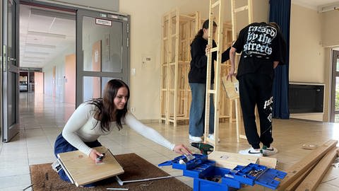 Schüler und Schülerinnen der 9. Klasse von der Friedrich-Schweitzer-Förderschule in Westerburg packen mit an und bauen Regale auf.