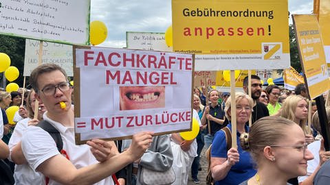 Ein Mann steht mit einem Plakat auf dem Münzplatz in Koblenz. Auf dem Plakat steht: Fachkräftemangel=Mut zur Lücke