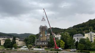 Ein Kran hebt die Dachkonstruktion des Quellenturms in Bad Ems direkt an der Lahn an
