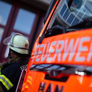 Das Symbolfoto zeigt einen Feuerwehrmann vor einem Feuerwehrauto: In Lahnstein ist die Feuerwehr zu einem Großeinsatz ausgerückt, nachdem Anwohner Brandgeruch gemeldet hatten.