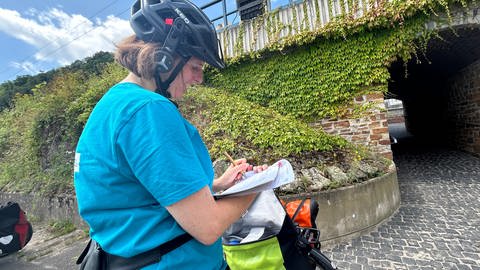 Claudia Kunz vom VCD macht sich auf der Fahrt über den Rheinradweg Notizen
