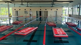 Das neue Hallenbad in Koblenz: In einem Schwimmbecken liegen rote Matten auf dem Wasser. 