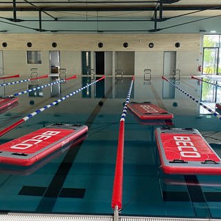 Das neue Hallenbad in Koblenz: In einem Schwimmbecken liegen rote Matten auf dem Wasser. 