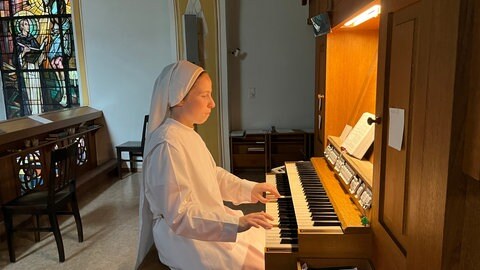 Schwester Clarita spielt Orgel in der Kirche des Arenberger Klosters.