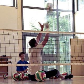 Die Sitzvolleyballer Heiko Wiesenthal und Francis Tonleu spielen Sitzvolleyball. Sie üben für die Paralympics in Paris.