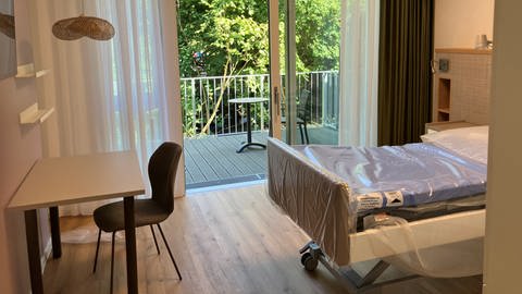 Ein Zimmer mit einem Krankenbett und einem Balkon