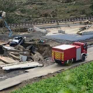 Feuerwehrauto vor zerstörtem Haus 