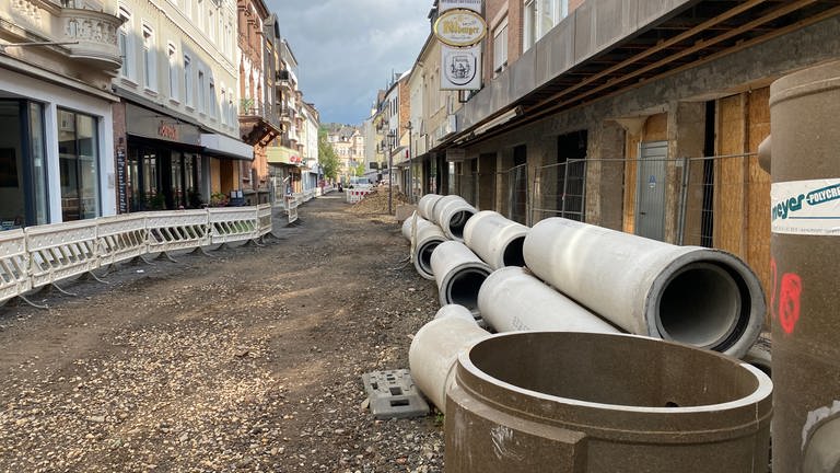 Ein Blick auf eine Straße in Bad Neuenahr-Ahrweiler, in der mehr als drei Jahre nach der Flut dicke Betonrohre liegen, die noch verlegt werden müssen. 