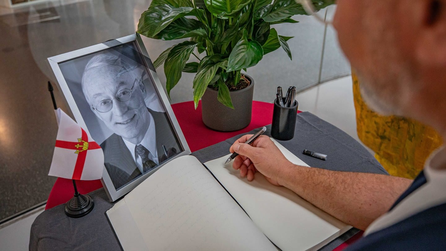 Ein Bild des Koblenzer Ex-Oberbuergermeisters Eberhard Schulte-Wissermann (SPD) steht vor einem Kondolenzbuch: Das liegt in der Stadtbibliothek im Forum Confluentes in Koblenz aus, damit sich Bürgerinnen und Bürger eintragen können.