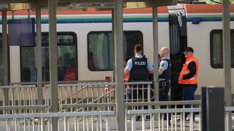 Bahnmitarbeiter und Bundespolizisten vor einem Zug in Niederlahnstein in dem es einen Messerangriff gegeben hatte.