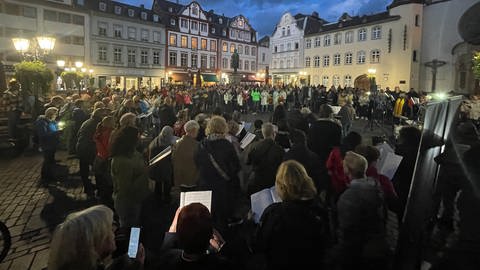 Auf dem Jesuitenplatz in Koblenz sind Menschen zum gemeinsamen Singen zusammengekommen..