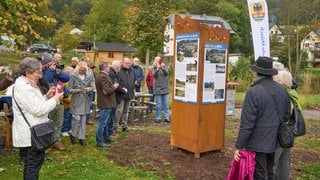 Bürger betrachten am 12. Oktober 2024 eine Stele zur Flutkatastrohe, die von der Bürgerinitiative "MemoriAHR", enthüllt wurde. Ein Weg der Erinnerung soll von der Quelle bis zur Mündung der Ahr und durch alle Orte führen, die von der Flutkatastrophe im Ahrtal betroffen waren.