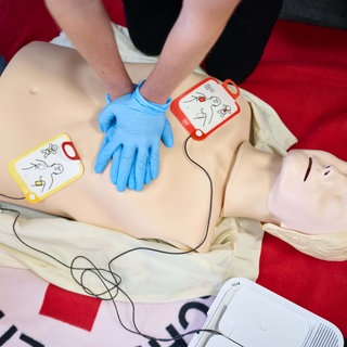 Ausbildung von Ersthelfern: Mit einer Puppe wird die Reanimation mit Hilfe eine Defibrillators geübt