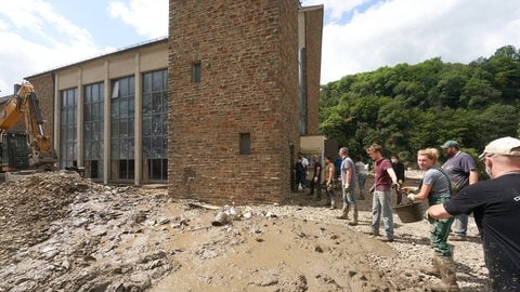 Freiwillige Helfer und Helferinnen reinigen die Kirche St. Andreas in Ahrbrück vom Schlamm des Hochwassers.