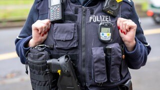 Polizistin mit Ausrüstungsweste und CO-Messgerät.