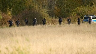 Polizisten durchkämmen das Gelände am Rodder Maar - zwei Tatverdächtige wurden nach einem Leichenfund festgenommen.