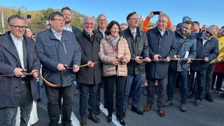 Baustelle B42-Lahnhochbrücke: Das obligatorische symbolische Band wird von der rheinland-pfälzischen Verkehrsministerin Daniela Schmitt (FDP) gemeinsam mit weiteren Amtsträgern durchgeschnitten.