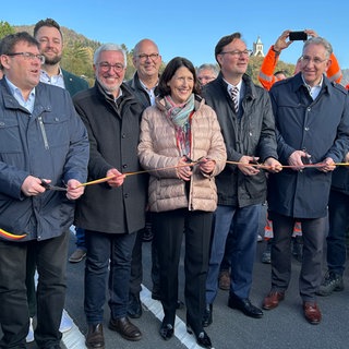 Baustelle B42-Lahnhochbrücke: Das obligatorische symbolische Band wird von der rheinland-pfälzischen Verkehrsministerin Daniela Schmitt (FDP) gemeinsam mit weiteren Amtsträgern durchgeschnitten.