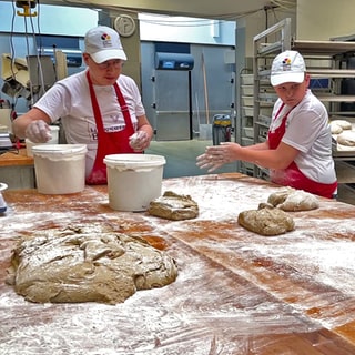 Clemens Wiede und Janic Schmitt lernen bei Bäckermeister Johannes Dhein, wie man Sauerteig-Brot backt