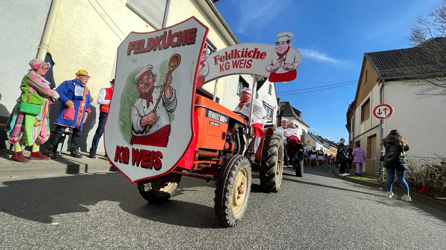 Ein umgebauter Traktor fährt beim Karnevalsumzug in Heimbach-Weis mit