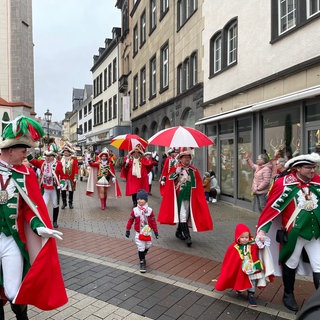 Karnevalisten in grün-roten Uniformen - schon die ganz Kleinen laufen mit.