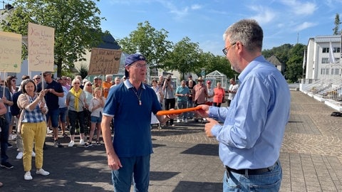 Ein Sprecher der Bürgerinitiative übergibt die Unterschriften an Markus Hof.