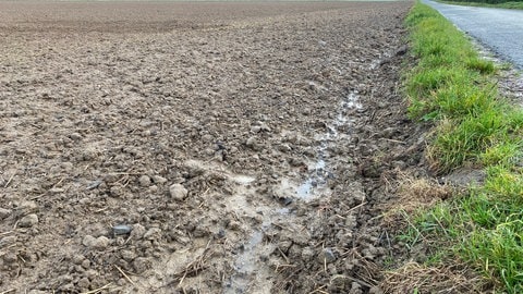 Wasser läuft Ackerfurche hinunter