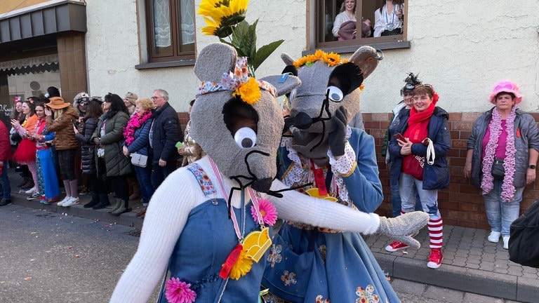 Zwei als Mäuse verkleidete Menschen laufen über eine Straße