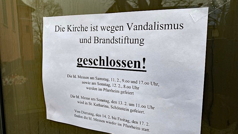 Am Eingang zur katholischen Kreuzerhöhungskirche in Wissen hängt nach der mutmaßlichen Brandstiftung ein Schild mit der Aufschrift "Wegen Vandalismus und Brandstiftung geschlossen"