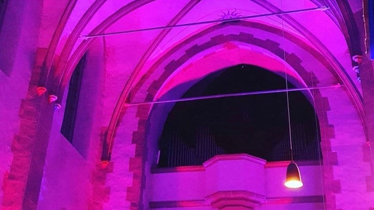 Der Altarraum der St. Martinskirche in Oberwesel erstrahlt bei der Lichtkunstaktion Rheinleuchten in lila.