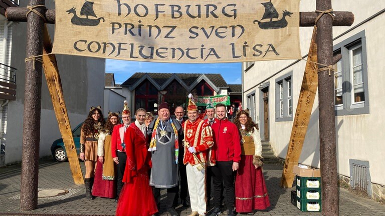 SWR-Reporter Andreas Krisam (Mi.) hat Confluentia Lisa (li.) und Prinz Sven (re.) schon am Montagmorgen getroffen, als sie sich auf den Rosenmontagszug vorbereitet haben. 