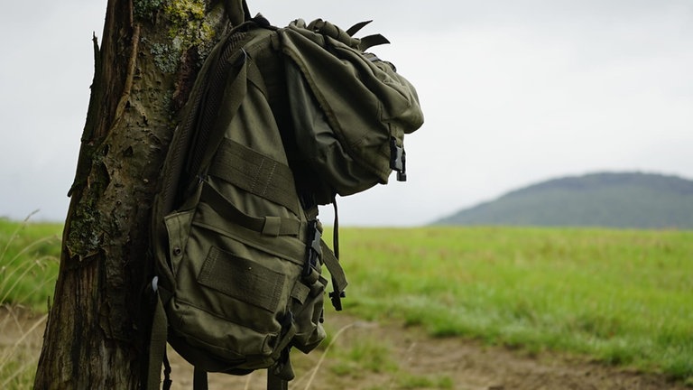 Ein Wanderrucksack hängt an einem Baum am Wanderweg "Zauberwald" bei Helferskirchen im Westerwald. 