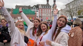 Vier junge Frauen strahlen beim Karnevalsauftakt in Koblenz am 11. November 2024 in die Kamera. 